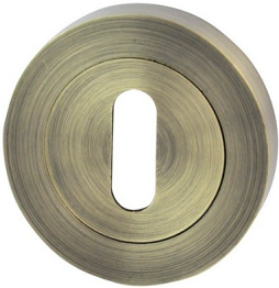 Okrągły, metalowy zamek z otworem w kształcie klucza, w kolorze mosiądzu.