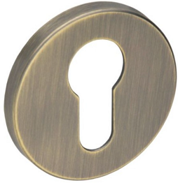 Okrągła, metalowa osłona zamka w kolorze mosiądzu z wycięciem w kształcie klucza.