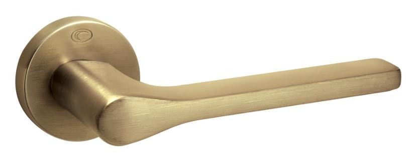 Złota klamka drzwiowa o nowoczesnym, minimalistycznym kształcie.