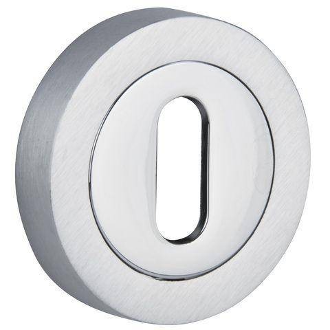 Metalowy element w kształcie okręgu z prostokątnym otworem w środku, o błyszczącej powierzchni.