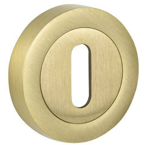 Okrągły, złoty element z otworem w kształcie prostokąta, prawdopodobnie uchwyt lub zamek.