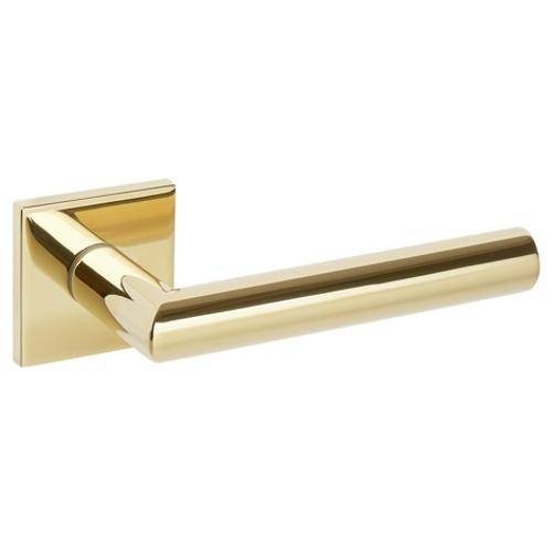 Złota klamka drzwiowa o prostym, nowoczesnym kształcie.