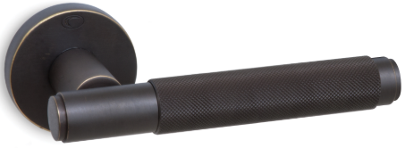 Ciemny uchwyt drzwiowy o teksturowanej powierzchni, zamocowany na okrągłej podstawie.