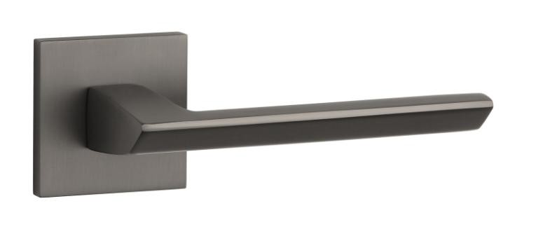 Nowoczesny uchwyt drzwiowy w odcieniu matowego czerni, zamocowany na prostokątnej płycie.