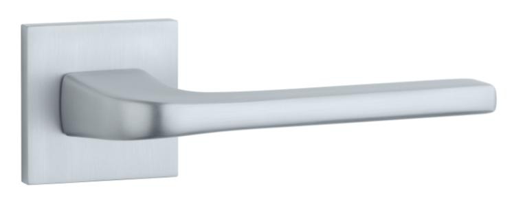 Metalowy uchwyt drzwiowy w minimalistycznym stylu, zamocowany na prostokątnej podstawie.