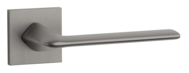 Nowoczesny uchwyt drzwiowy w matowym, szarym wykończeniu, zamocowany na prostokątnej płycie.