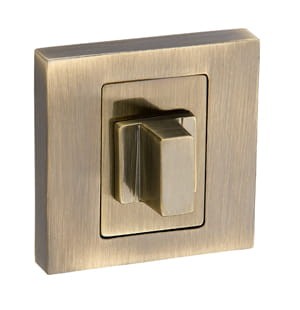 Złoty włącznik światła o prostokątnym kształcie, umieszczony na metalowej płycie.