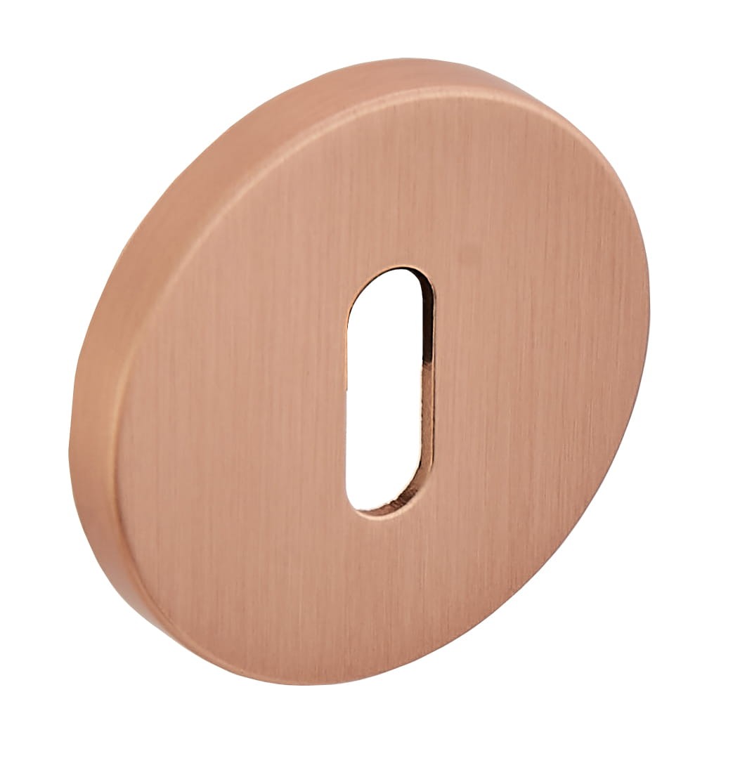 Okrągła, mosiężna wkładka zamka z prostokątnym otworem.