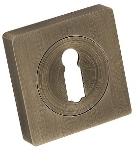Kwadratowa, metalowa osłona zamka z otworem w kształcie klucza, w kolorze brązowym.