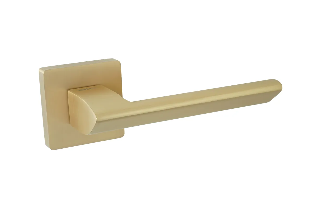 Złota klamka drzwiowa o nowoczesnym, prostym designie na kwadratowej podstawie.